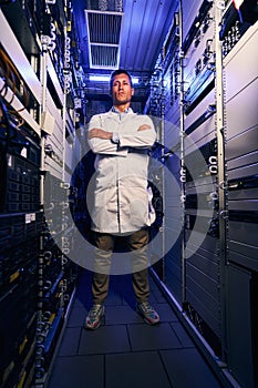 Serene IT technician standing alone in server room