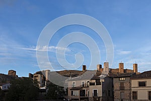 serene townscape with historical towers and a clear blue sky, accentuated by a solitary cloud