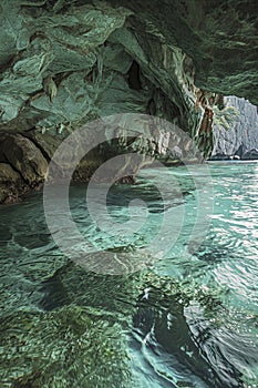 a serene underwater cave with turquoise water, reflecting the textured, rocky ceiling above. It s a tranquil scene