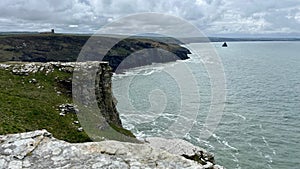 Serene view of a beach with clear blue ocean water and rocky shoreline in Cornwall.