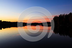 Serene view of calm lake and sunset clouds