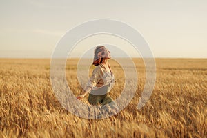 Serene woman enjoying freedom in golden wheat field