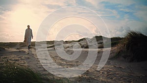 Serene woman walking sand dunes. Calm model silhouette enjoying seaside morning