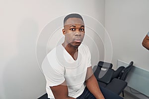 Serene young man seated in physiotherapist office