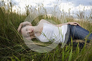Serene young woman resting in meadow