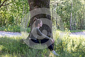 Serenity Amidst Green: Thoughtful Young Woman by a Tree