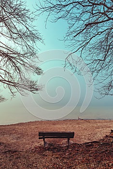 Serenity of Bohinj Lake on a foggy morning with empty wooden bench