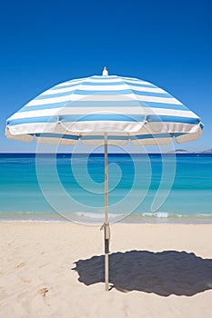 Serenity by the Sea: Striped Sun Umbrella on a Golden Sandy Beach