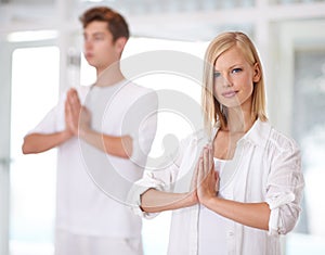 Serentiy. Shot of two young people doing yoga together.