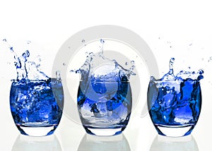 Serial arrangement of blue liquid splashing in tumbler