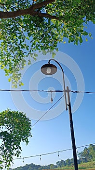 A series of decorative lights adorning the garden in the hilly area with a bright blue sky