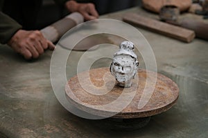 Series of head-statue handcrafted by an artisan in clay, traditional Asian, with potter hands