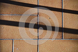 Shadow on brown ceramic tiles