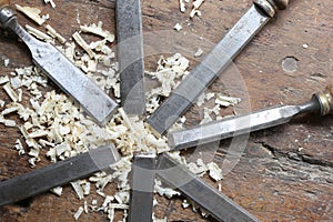 series of many steel blades many chisels and sawdust chippings i