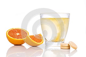 Series of orange flavored vitamin c effervescent tablet dropped and dissolve in glass of water