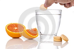 Series of orange flavored vitamin c effervescent tablet dropped and dissolve in glass of water