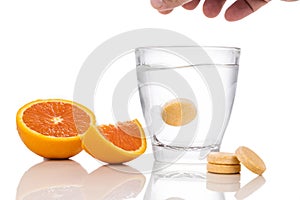 Series of orange flavored vitamin c effervescent tablet dropped and dissolve in glass of water