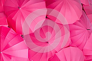 Series of pink umbrellas all together seen from above composing a abstract background