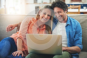 Series and snuggles, it doesnt get any better than this. a happy mature couple using a laptop together on the sofa at