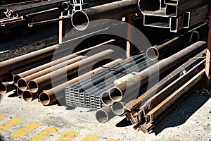 Series of steel pipes and tubes neatly arranged and stacked on a raised platform