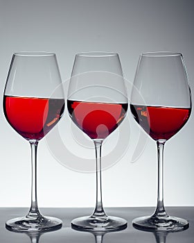 Series of three glasses of wine on gray