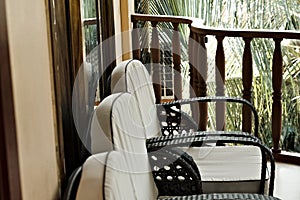 A series of white vintage chairs in the balcony with a wooden railing Ari Atoll,Maldives