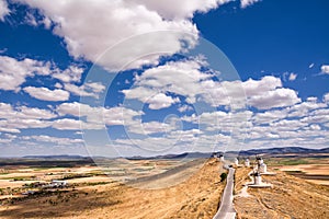 Series of windmill of Consuegra on the hill and in the background the plain of La Mancha (Spain