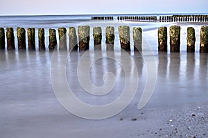 A series of wooden breakwaters and a pier on a sandy beach on the island of Wolin photo