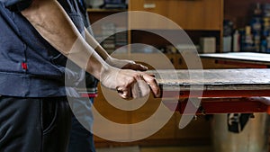 Serigraphy production. printing images on t-shirts by silkscreen method in a design studio. selective focus photo of male hands.