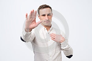Seriou young man showing stop gesture. Social distance concept