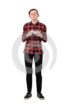 Serious adolescent boy playing video games isolated over white background. Intent teen guy stand all ears holding a joystick photo
