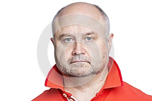 Serious adult bald man in an orange tank top. Sadness and depression. Isolated on white background. Close-up