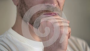 Serious adult man with beard rubbing chin, having doubts, thinking, close-up