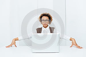 Serious african american businesswoman sitting and posing with laptop