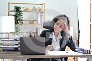 Serious african american businesswoman sitting at table looking at laptop screen. Ethnic woman read message email with important