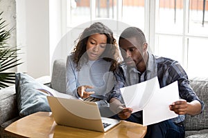 Serious African American couple discussing paper documents