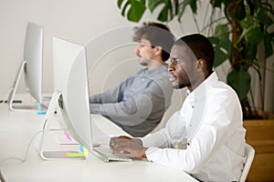 Serious African American employee busy writing business email