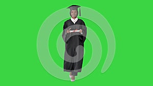 Serious African American female graduate walking with diploma on a Green Screen, Chroma Key.