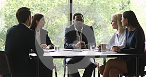 Serious african american team leader in eyeglasses holding business meeting.