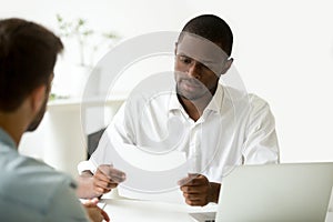 Serious african businessman reading document or considering cont