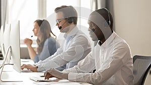 Serious african call center agent in headset working on computer