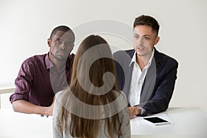 Serious african and caucasian hr managers interviewing female jo