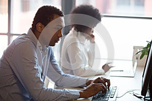 Serious african employee working on computer at coworking space