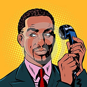 Serious african man talking on a retro phone