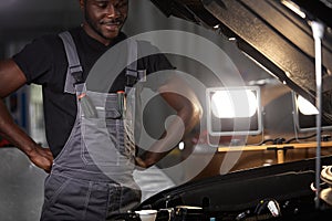 Serious afro american male stand above car thinking