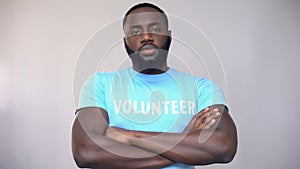 Serious Afro-American volunteer standing with hands crossed, altruistic activity photo