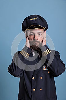 Serious airplane aviator covering ears with hands