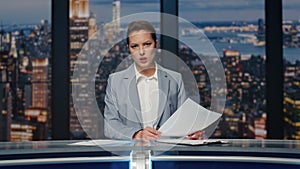 Serious anchorwoman talking news at evening studio closeup. Woman host speaking
