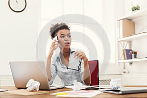 Serious angry business woman at work talking on phone