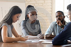 Serious anxious colleagues gathered together in boardroom solve work problems